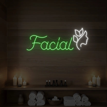 Photo of the 'Facial' neon sign with a botanical face silhouette glowing in green against a styled interior wall.
