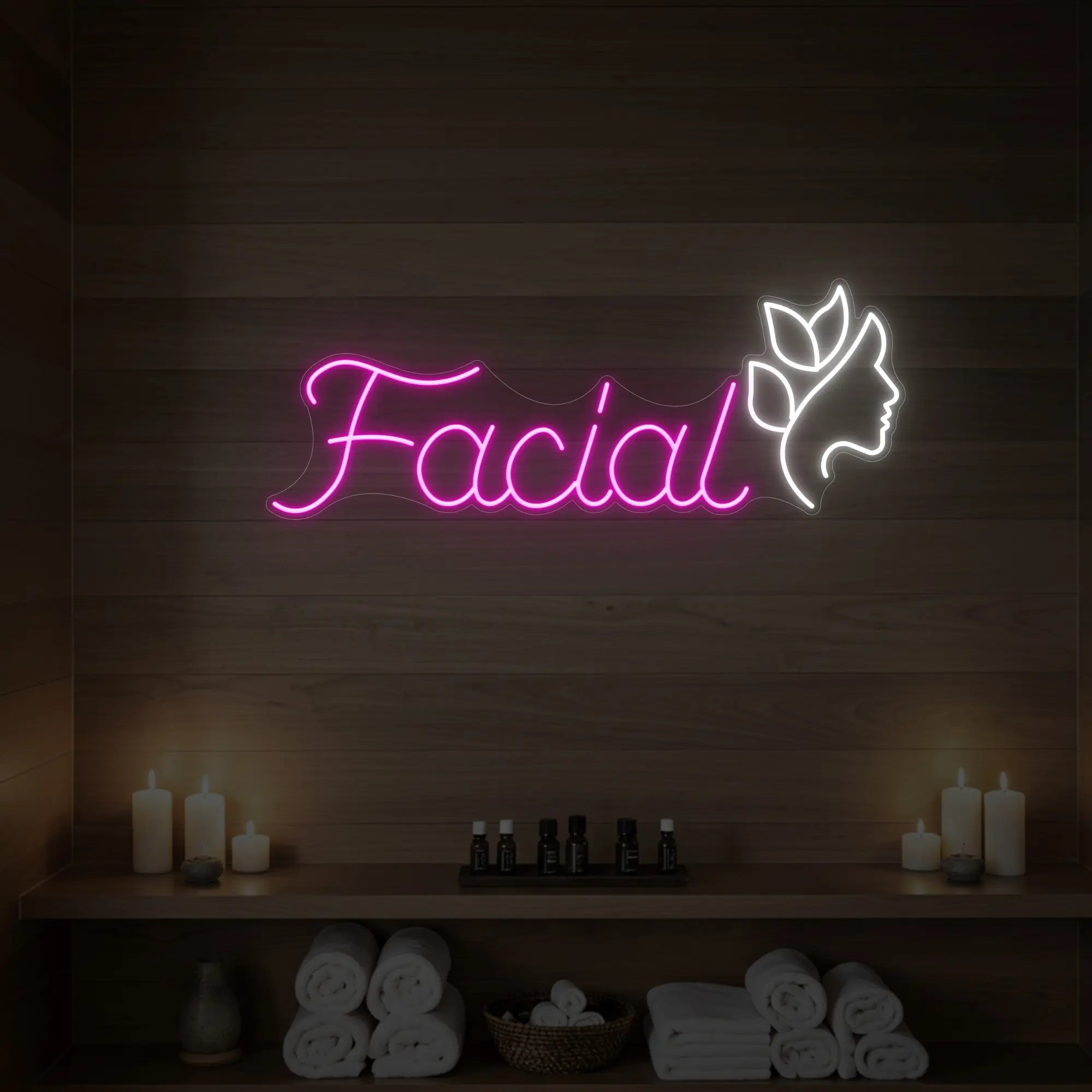 Photo of the 'Facial' neon sign with a botanical face silhouette glowing in light pink against a styled interior wall.