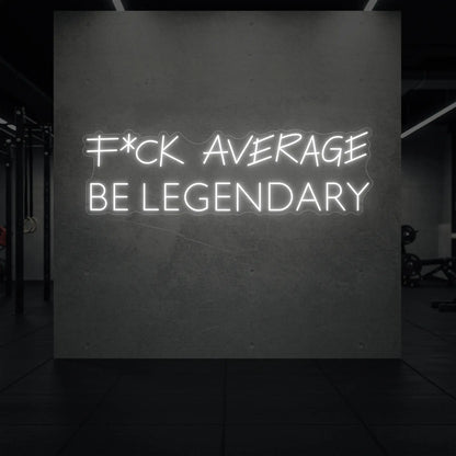  'F*ck Average Be Legendary' neon sign glowing in cool white against a styled interior wall.
