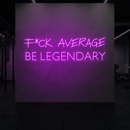  'F*ck Average Be Legendary' neon sign glowing in deep pink against a styled interior wall.
