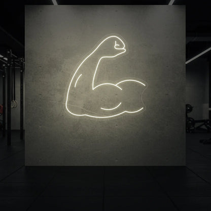  'Flexing Bicep Arm' neon sign glowing in warm white against a styled interior wall.