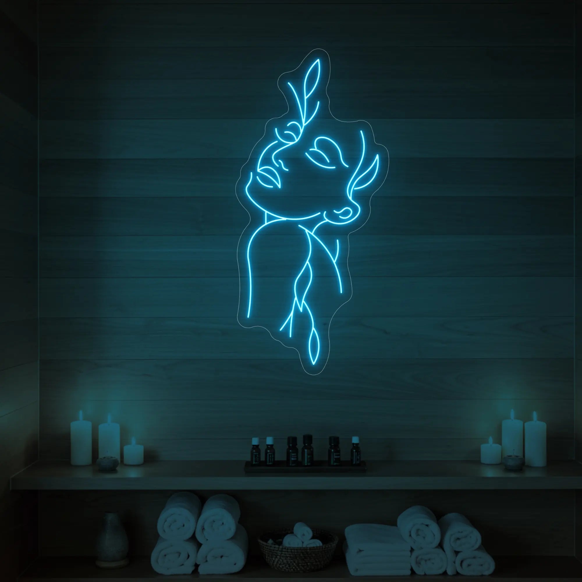 Photo of the 'Flower Girl' neon sign featuring a minimalist face and leaf line art glowing in ice blue against a styled interior wall.