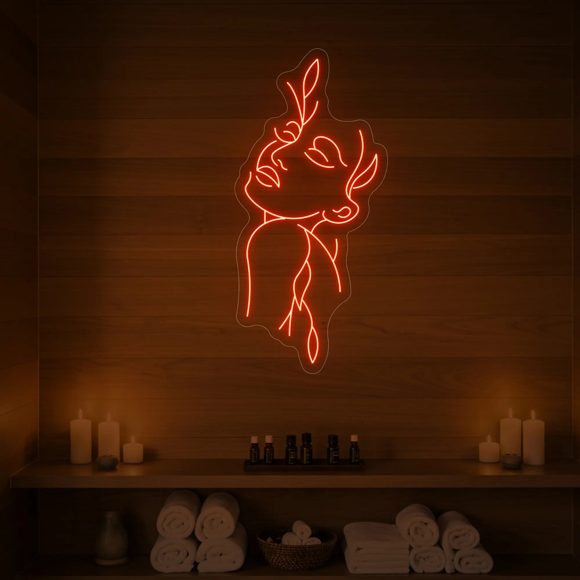 Photo of the 'Flower Girl' neon sign featuring a minimalist face and leaf line art glowing in golden yellow against a styled interior wall.


