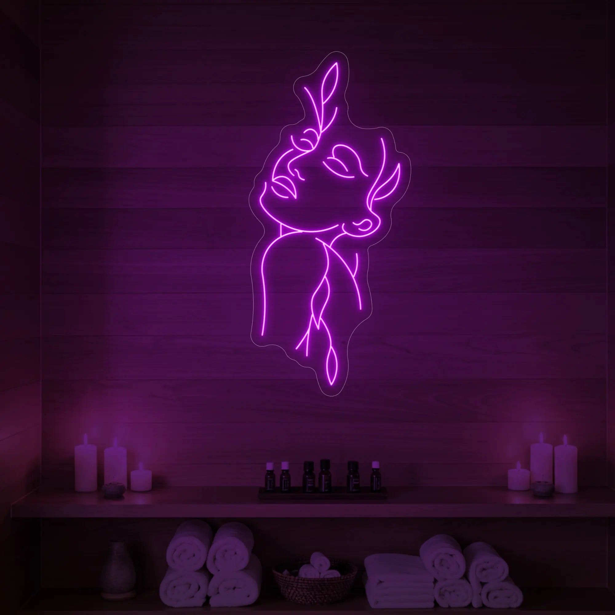Photo of the 'Flower Girl' neon sign featuring a minimalist face and leaf line art glowing in deep pink against a styled interior wall.