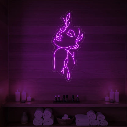 Photo of the 'Flower Girl' neon sign featuring a minimalist face and leaf line art glowing in deep pink against a styled interior wall.