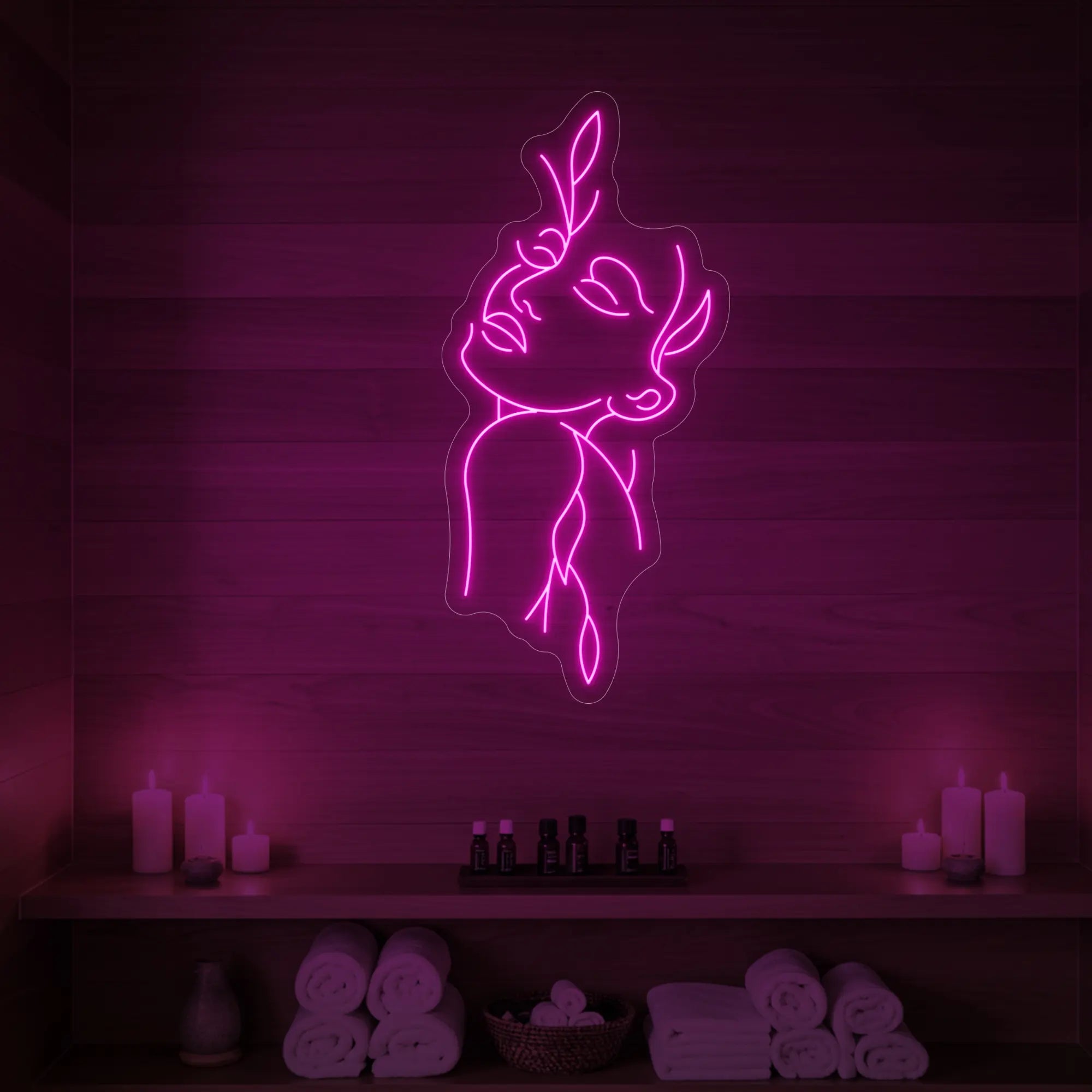 Photo of the 'Flower Girl' neon sign featuring a minimalist face and leaf line art glowing in light pink against a styled interior wall.