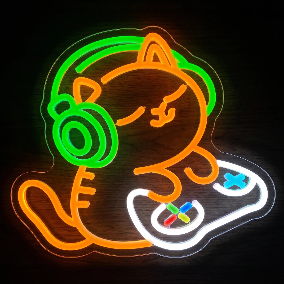 Gaming cat LED neon sign with orange cat, green headphones and multicolor game controller on clear acrylic backing.