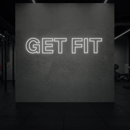  'Get Fit' neon sign glowing in cool white against a styled interior wall.

