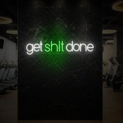  'Get Shit Done' neon sign glowing in green against a styled interior wall.