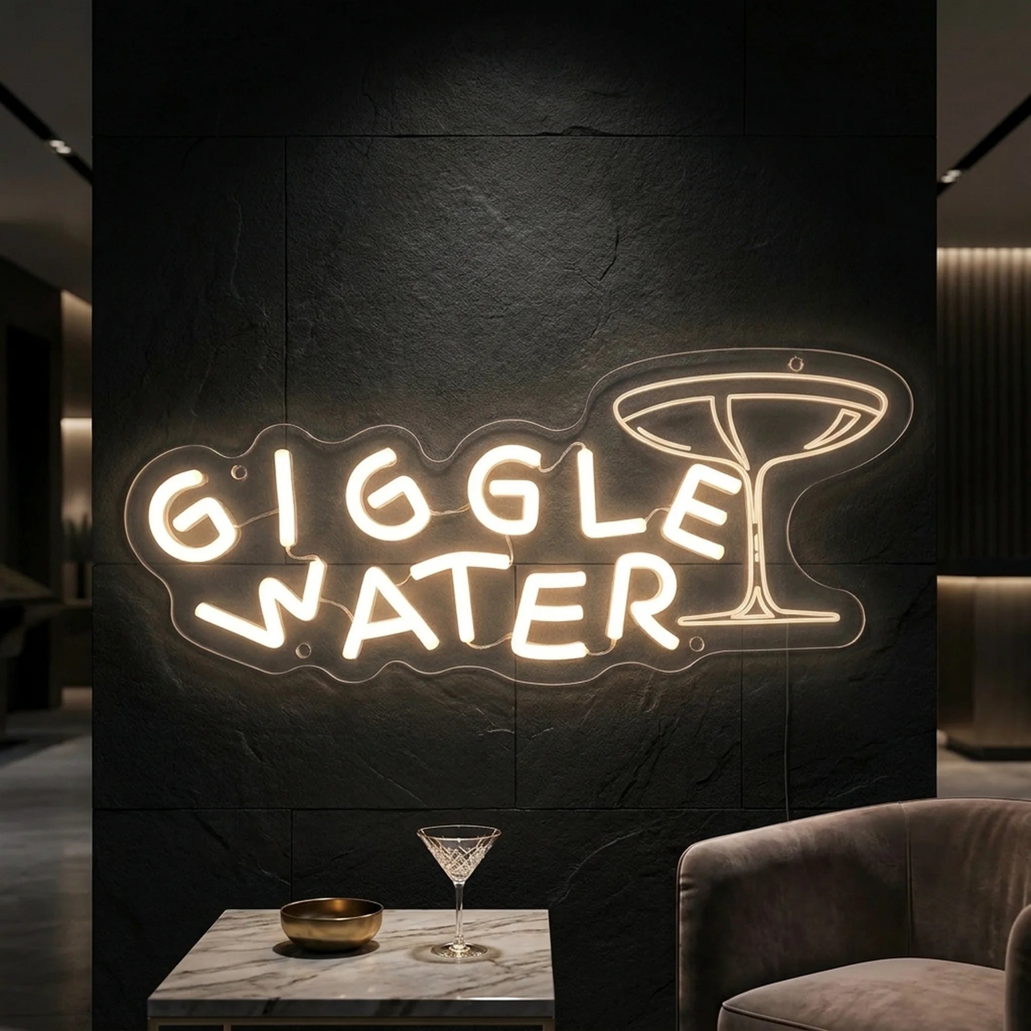 Photo of the 'Giggle Water' neon sign glowing in warm white against a styled interior wall.