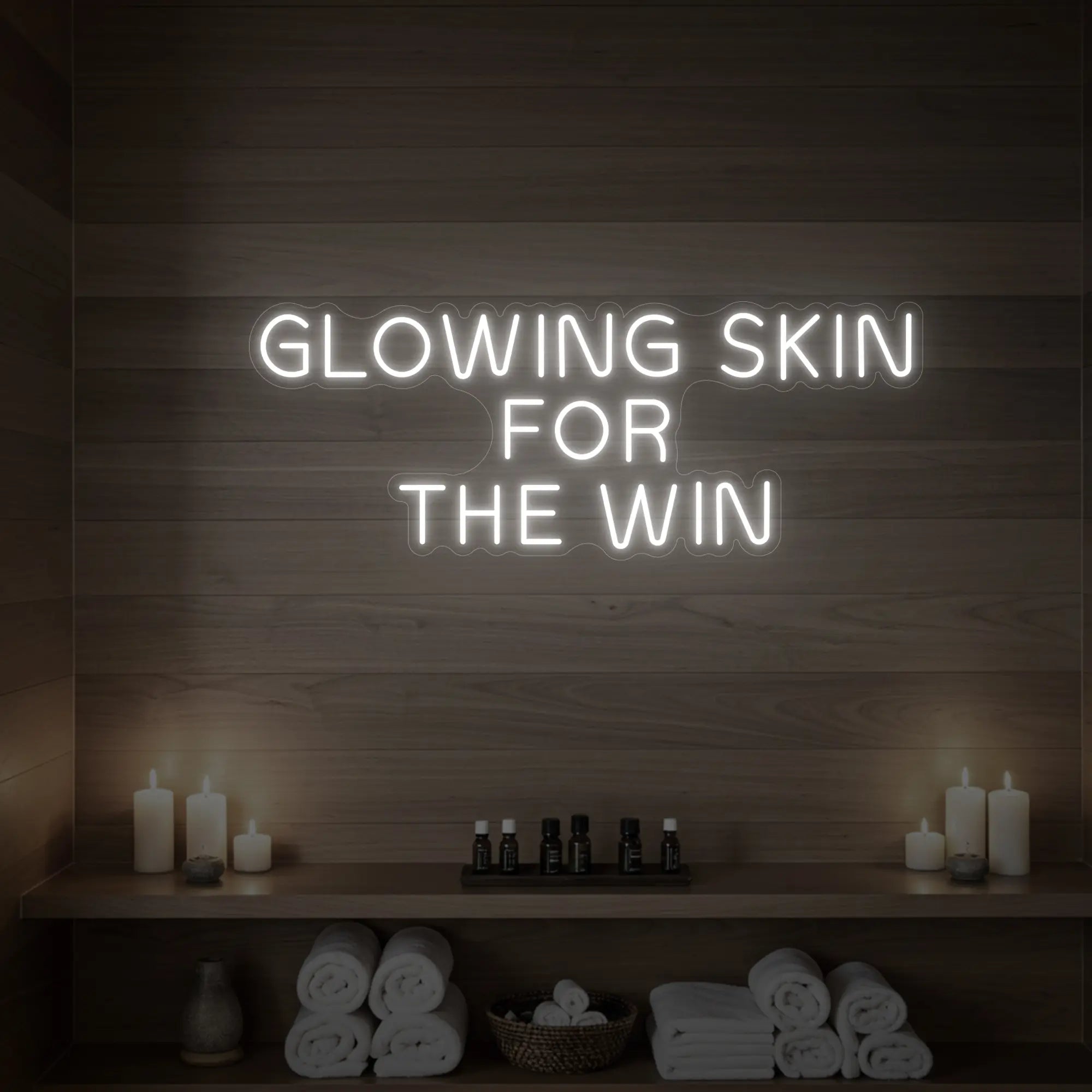 Photo of the 'GLOWING SKIN FOR THE WIN' neon sign glowing in cool white against a styled interior wall.