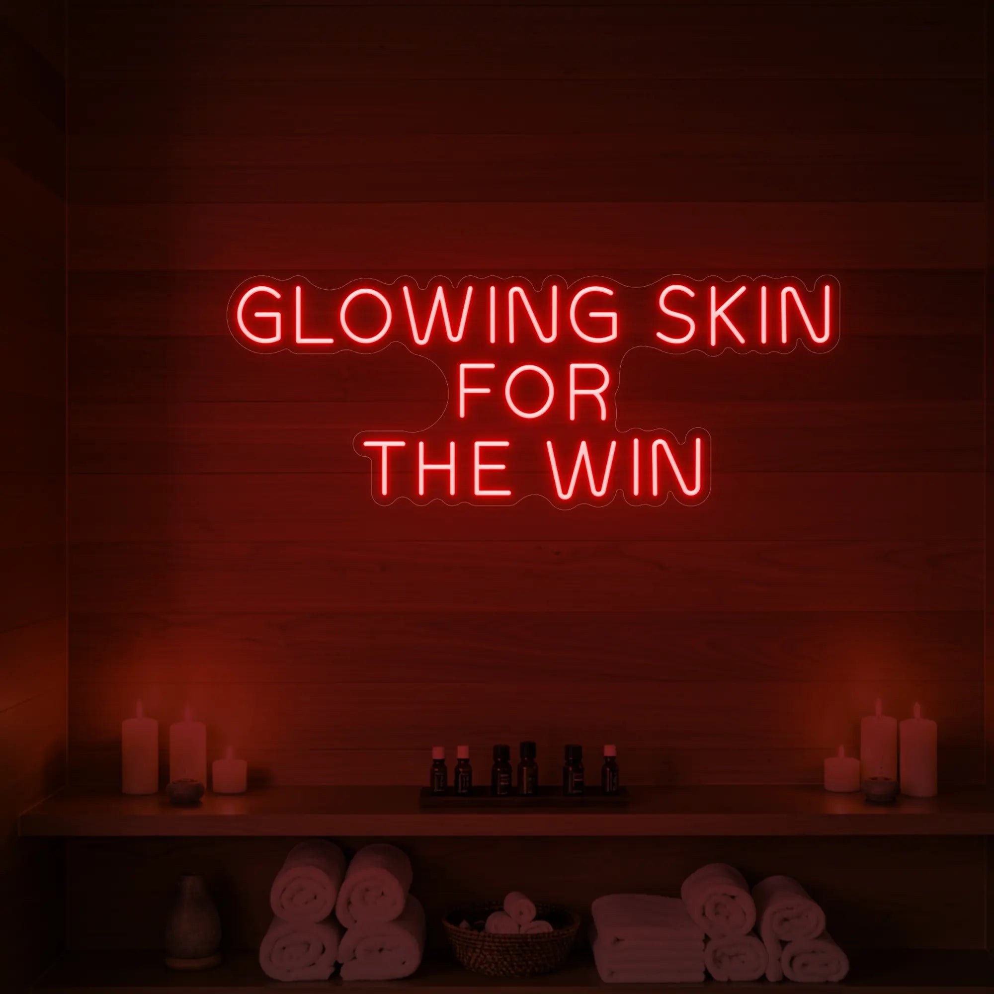 Photo of the 'GLOWING SKIN FOR THE WIN' neon sign glowing in red against a styled interior wall.