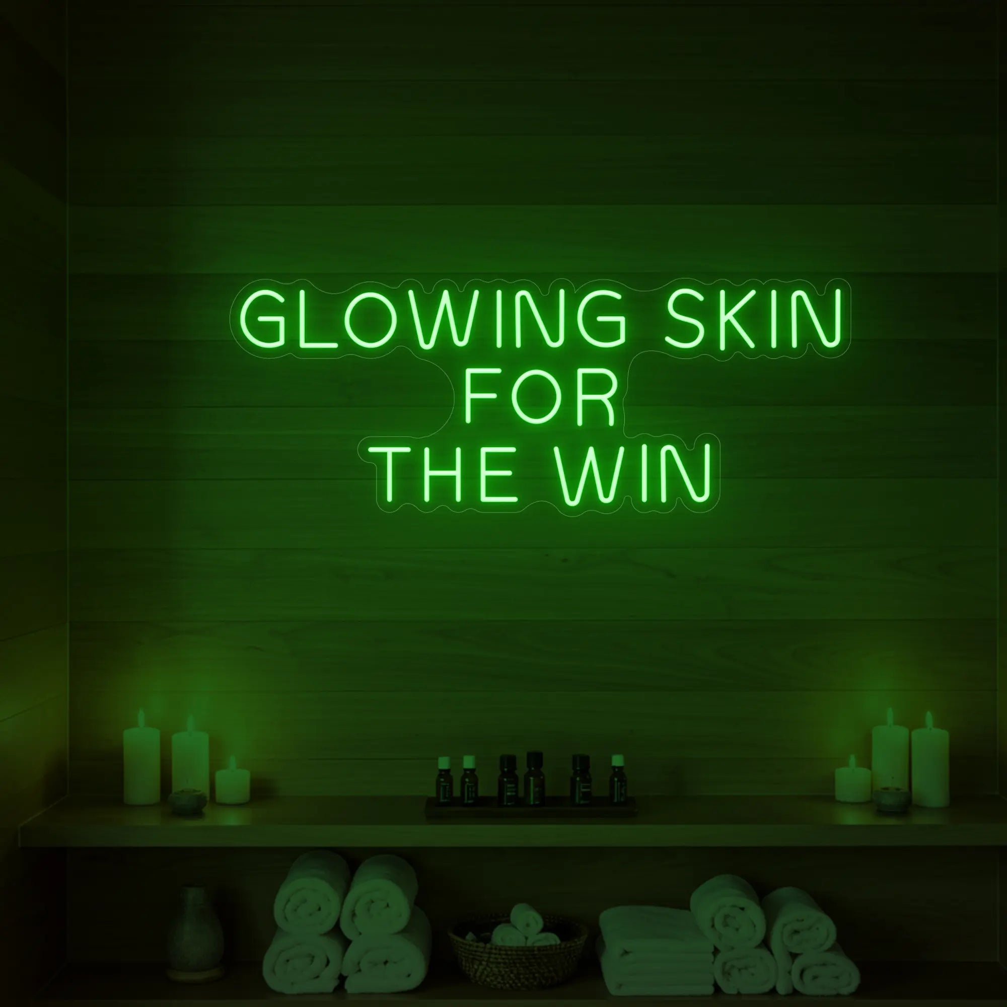 Photo of the 'GLOWING SKIN FOR THE WIN' neon sign glowing in green against a styled interior wall.