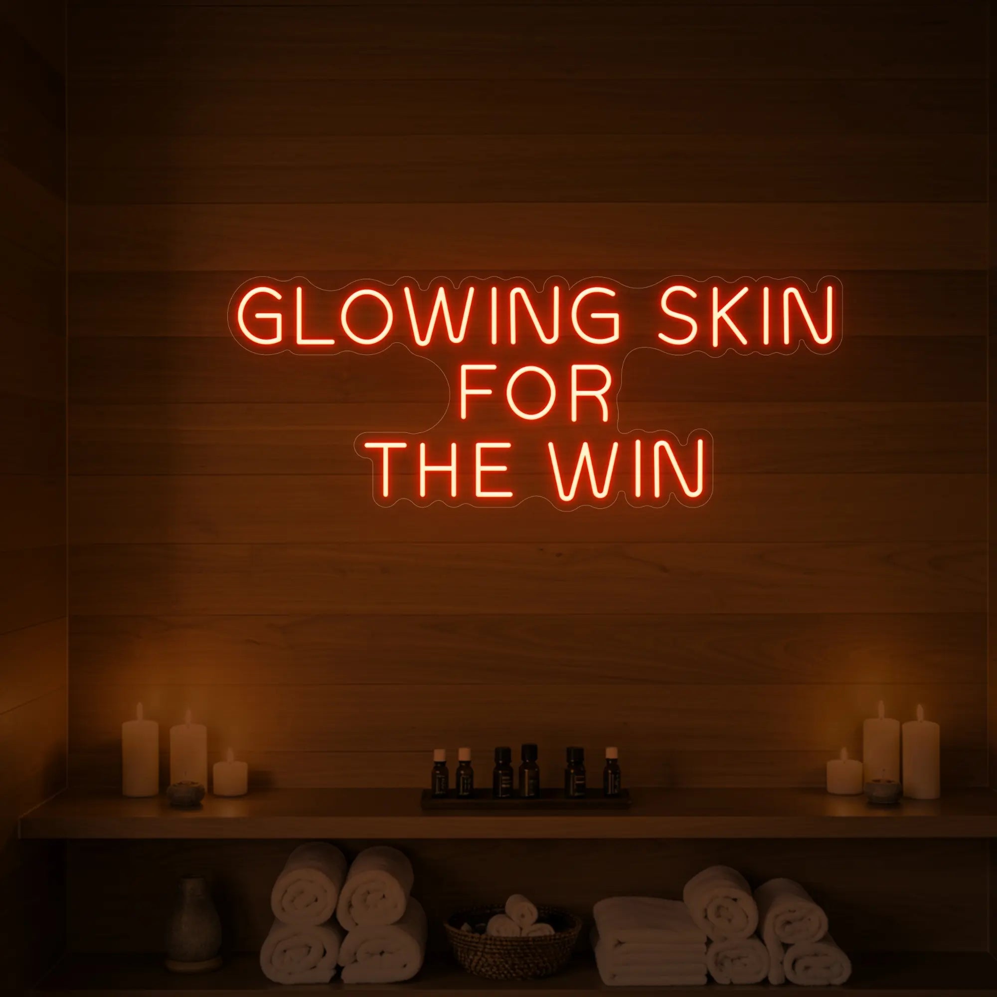 Photo of the 'GLOWING SKIN FOR THE WIN' neon sign glowing in golden yellow against a styled interior wall.