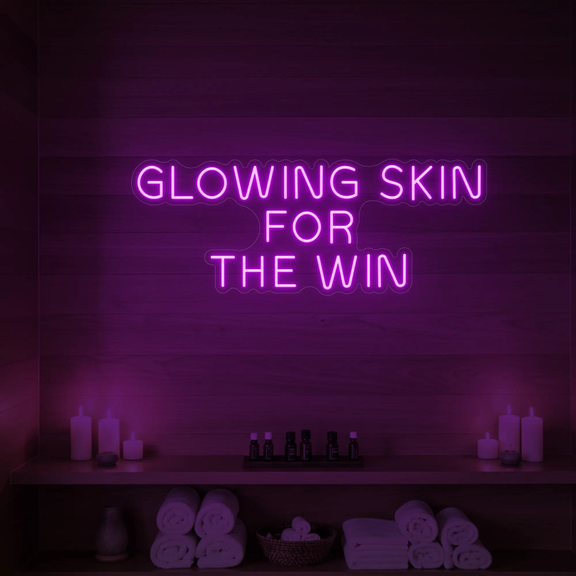 Photo of the 'GLOWING SKIN FOR THE WIN' neon sign glowing in deep pink against a styled interior wall.