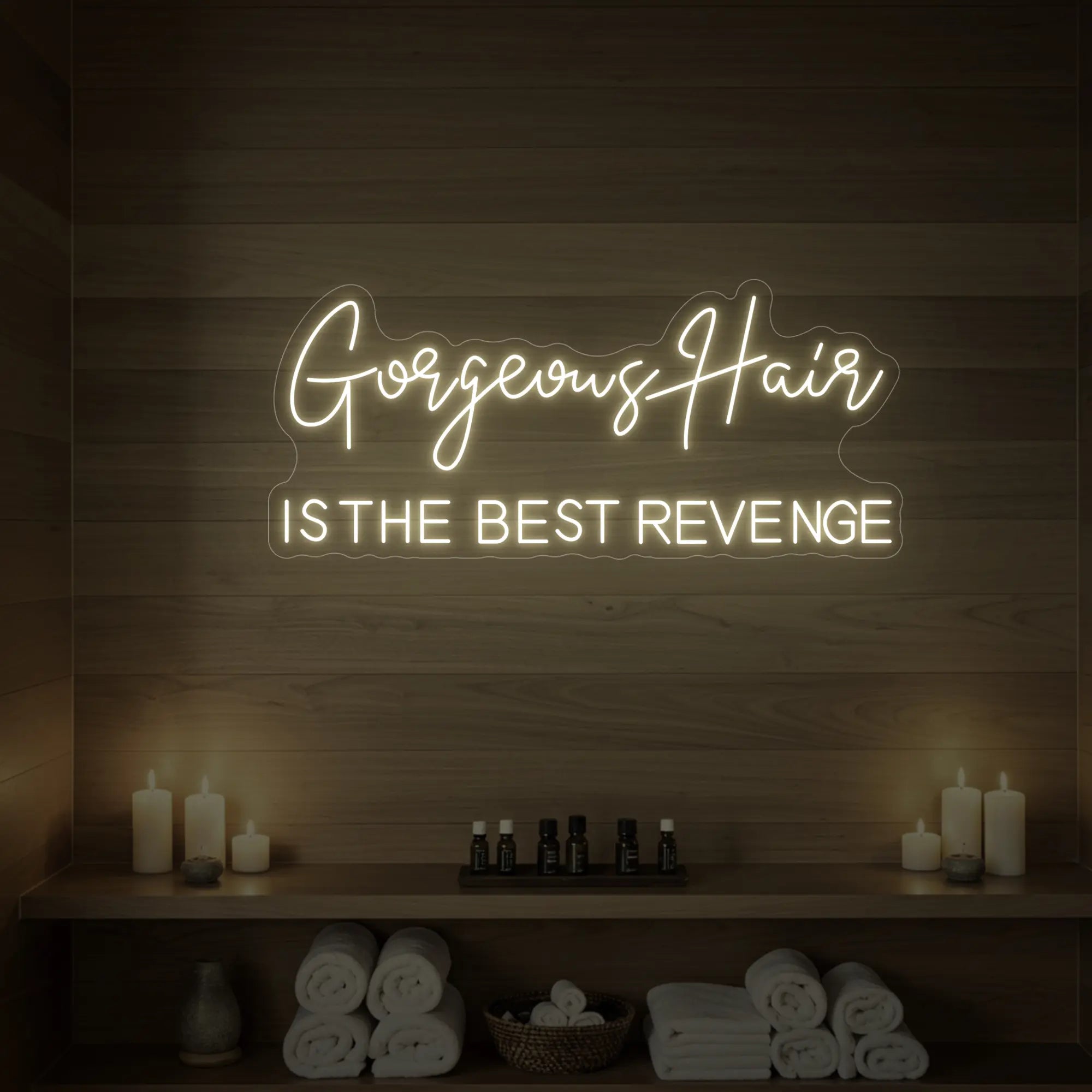 Photo of the 'Gorgeous Hair is the Best Revenge' neon sign glowing in warm white against a styled interior wall.