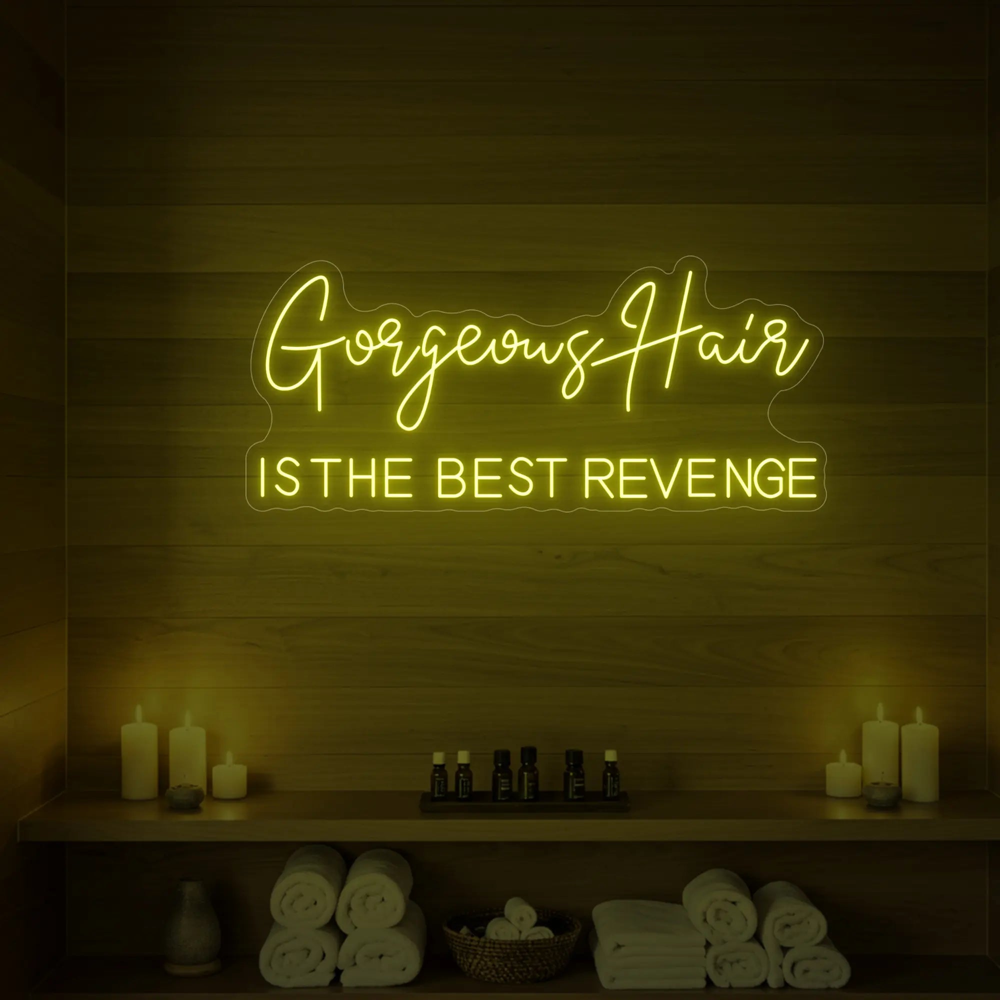 Photo of the 'Gorgeous Hair is the Best Revenge' neon sign glowing in lemon yellow against a styled interior wall.