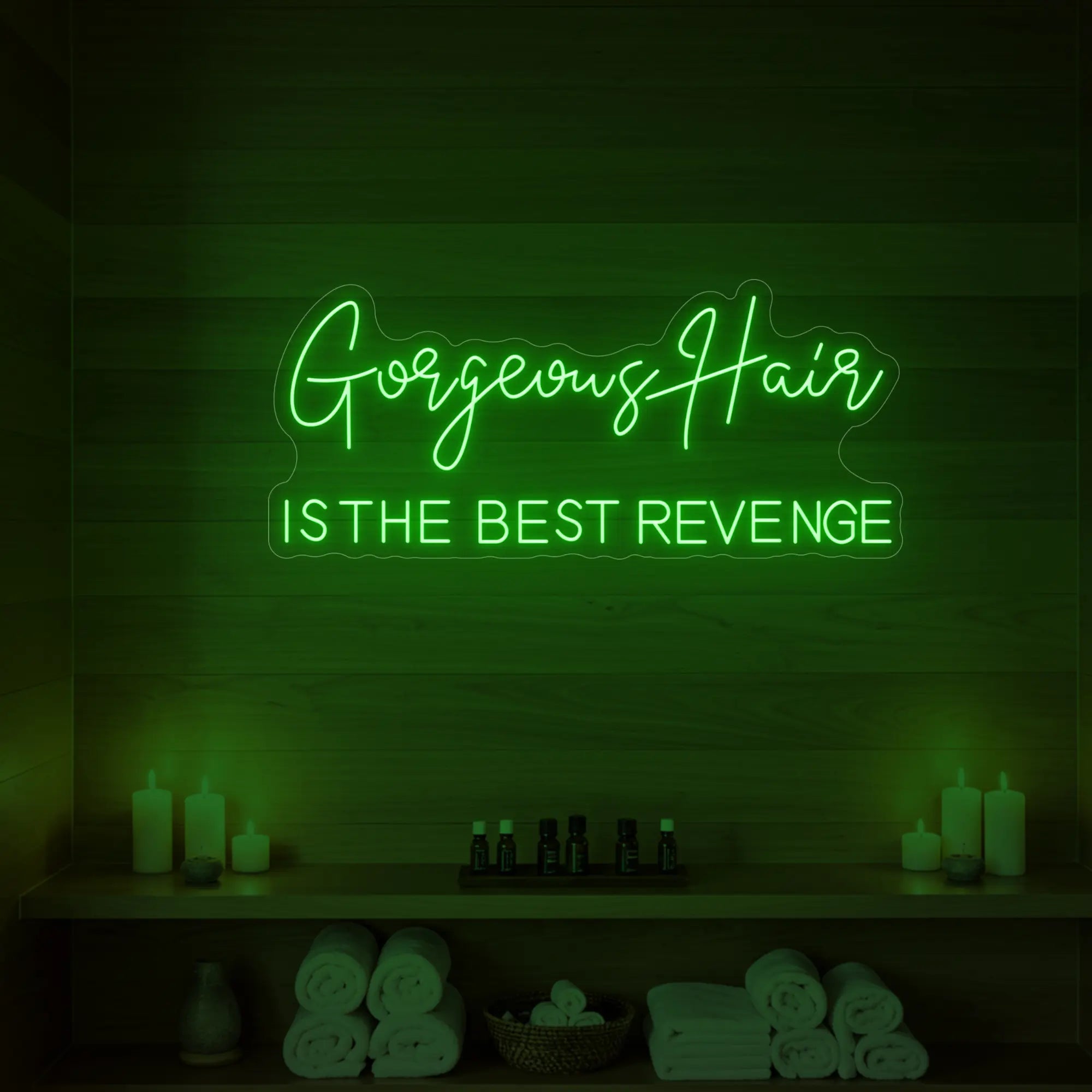 Photo of the 'Gorgeous Hair is the Best Revenge' neon sign glowing in green against a styled interior wall.