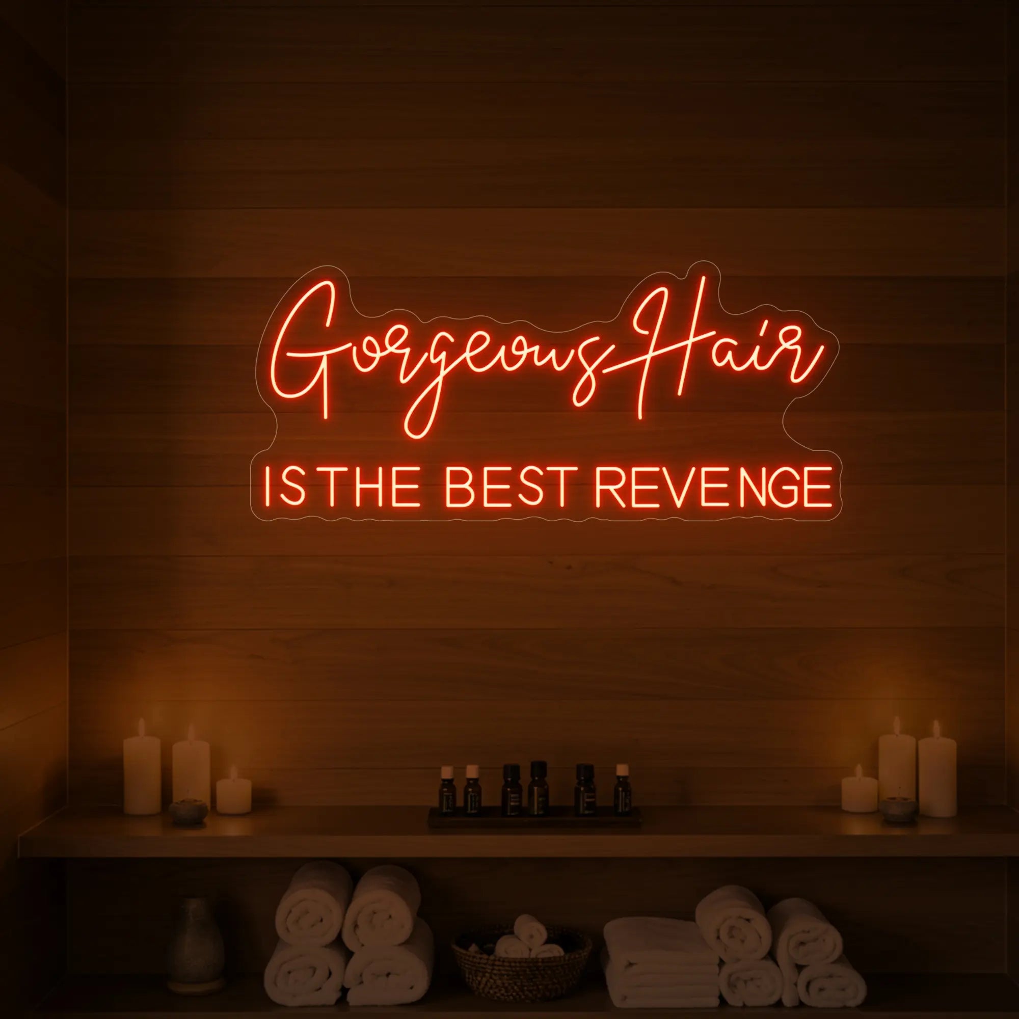Photo of the 'Gorgeous Hair is the Best Revenge' neon sign glowing in golden yellow against a styled interior wall.