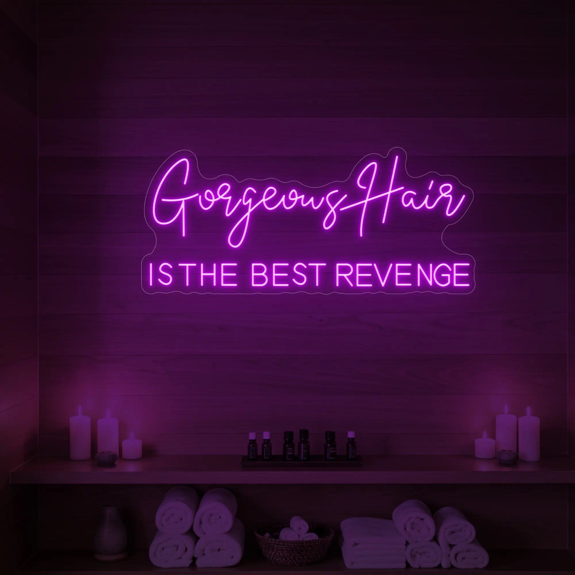 Photo of the 'Gorgeous Hair is the Best Revenge' neon sign glowing in deep pink against a styled interior wall.
