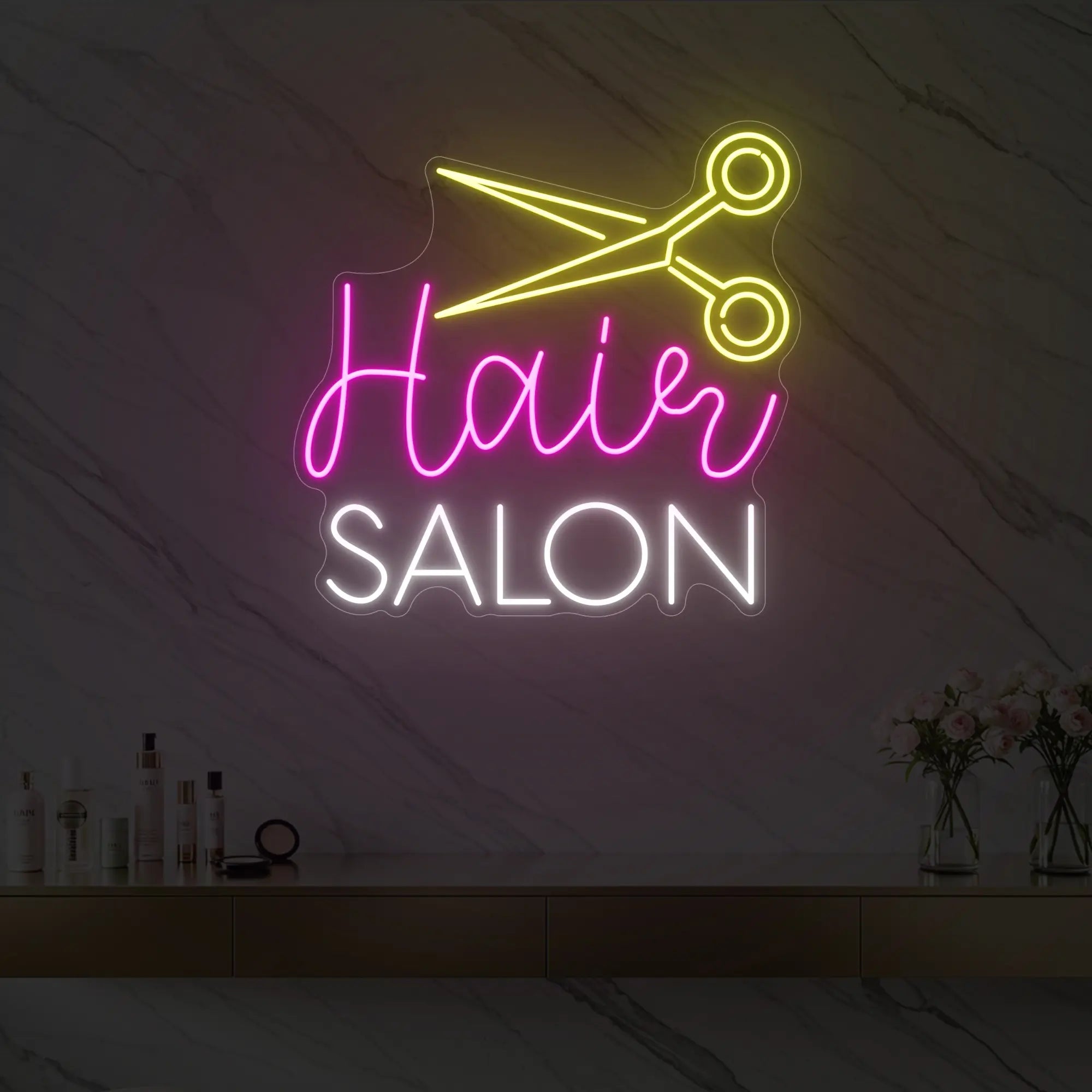 Photo of the 'Hair Salon' neon sign with a scissors icon glowing in cool white, pink, and lemon yellow against a styled interior wall.