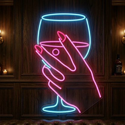 Photo of the 'Hand Holding Cocktail Glass' neon sign glowing in multi-color against a styled interior wall.