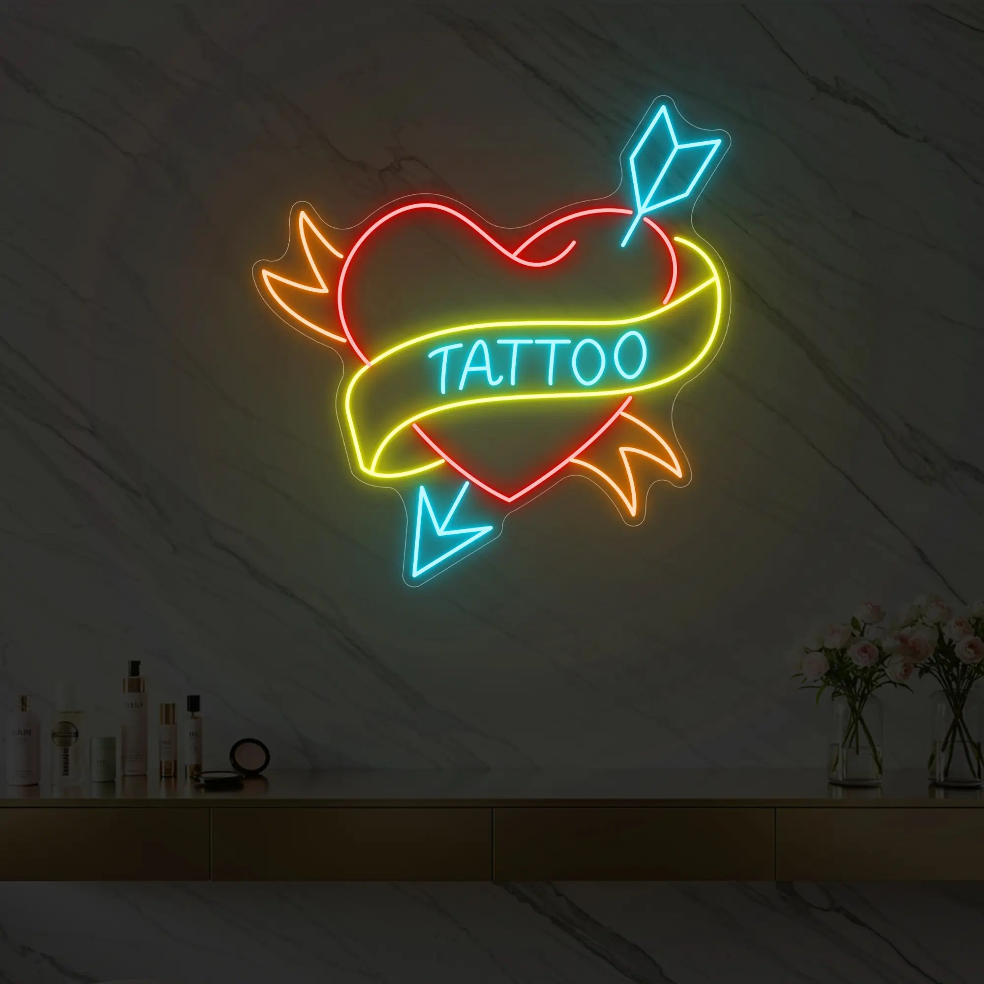 Photo of the 'Heart Tattoo neon sign glowing in ice blue, red, lemon yellow and golden yellow against a styled interior wall.