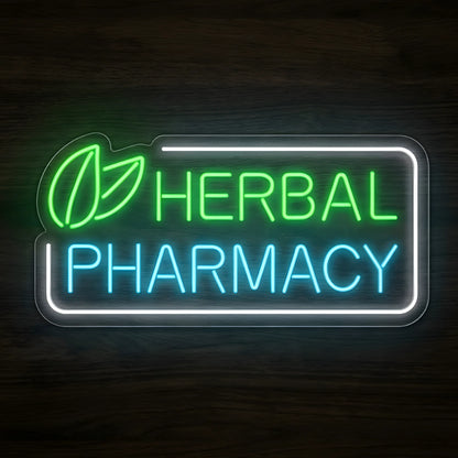 Herbal Pharmacy LED Neon Sign featuring green leaf graphics, glowing green HERBAL lettering, cyan PHARMACY text, and a white rectangular border on clear acrylic against a dark wooden wall.