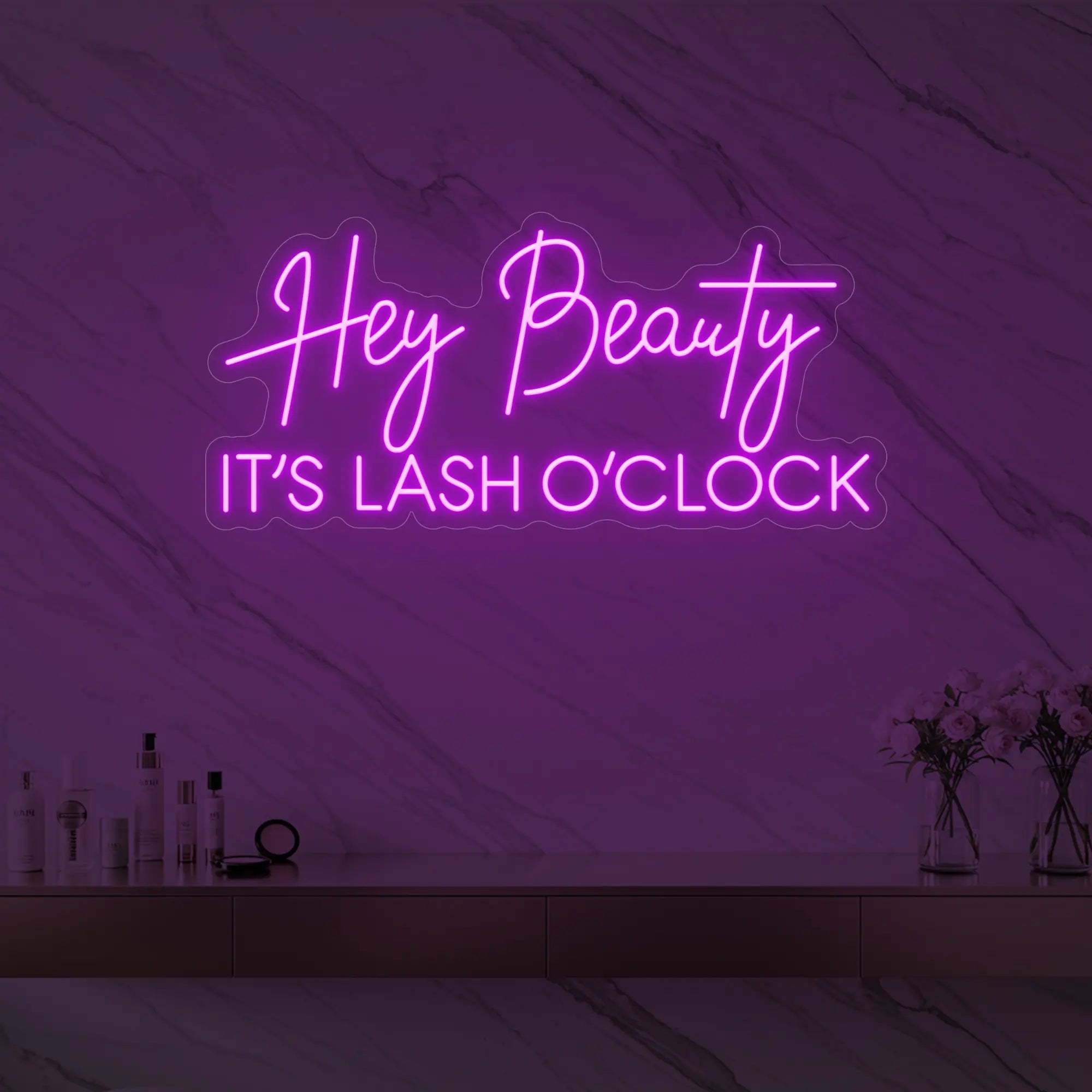 Photo of the 'Hey Beauty IT’S LASH O’CLOCK' neon sign glowing in deep pink against a styled interior wall.