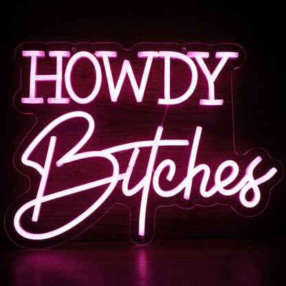 Howdy Bitches LED neon sign featuring bold Western-style Howdy lettering and cursive Bitches text glowing in vibrant pink on clear acrylic.