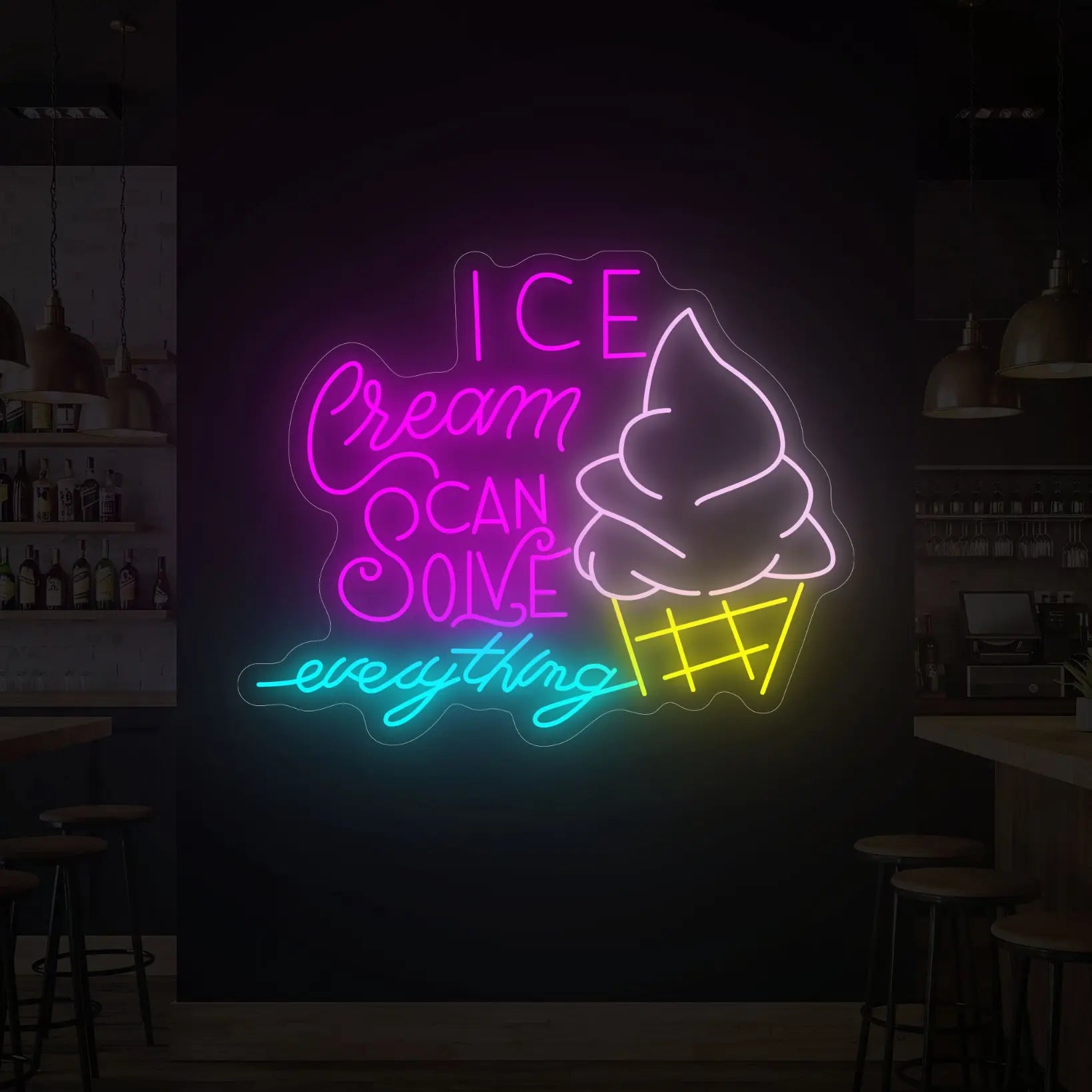 Photo of the 'ICE CREAM CAN SOLVE EVERYTHING' neon sign glowing in multi-color against a styled interior wall.