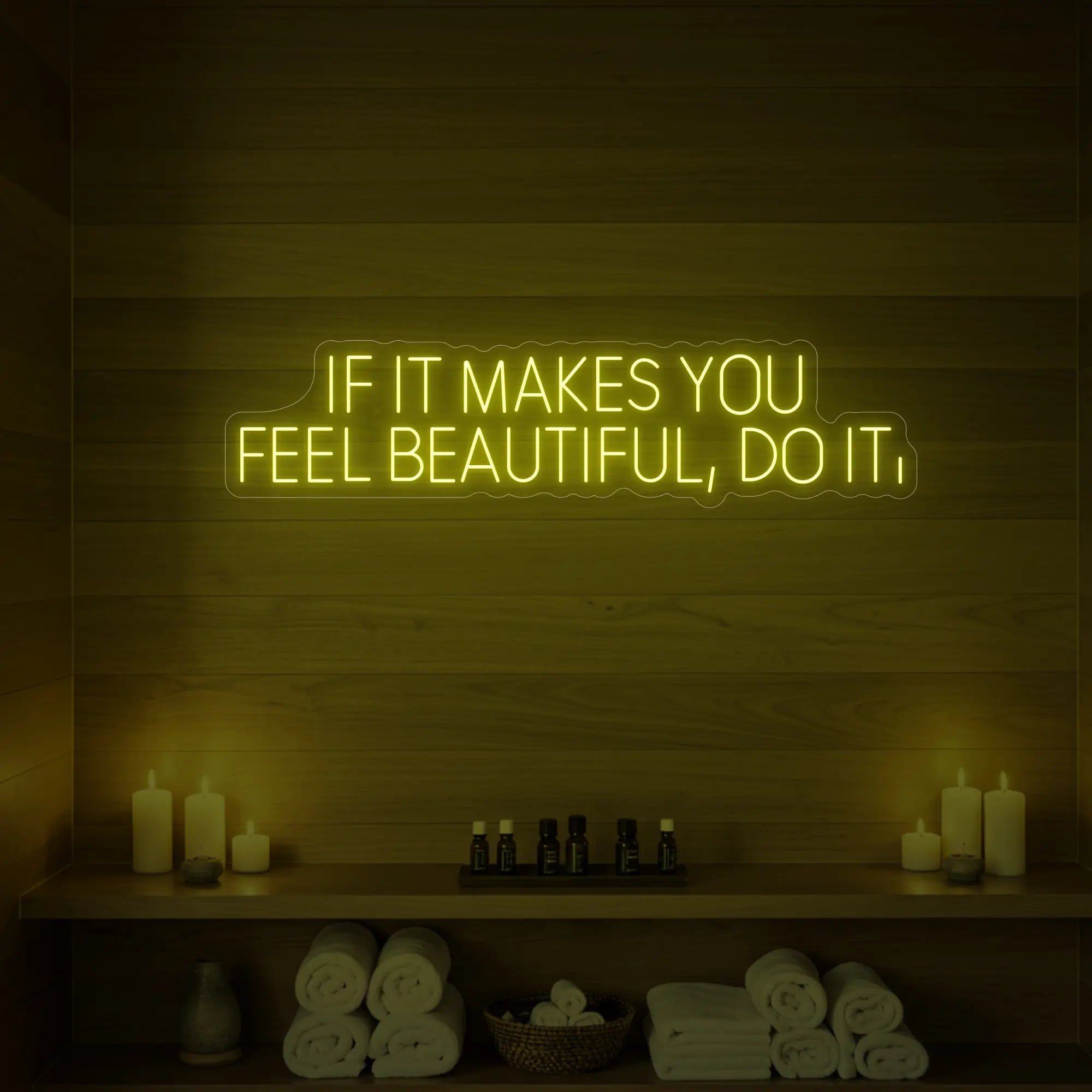Photo of the 'IF IT MAKES YOU FEEL BEAUTIFUL, DO IT.' neon sign glowing in lemon yellow against a styled interior wall.