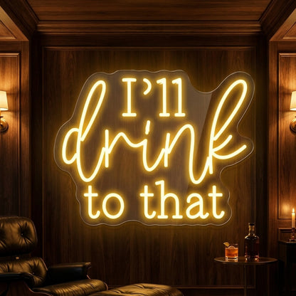 Photo of the 'I’ll Drink to That' neon sign glowing in lemon yellow against a styled interior wall.