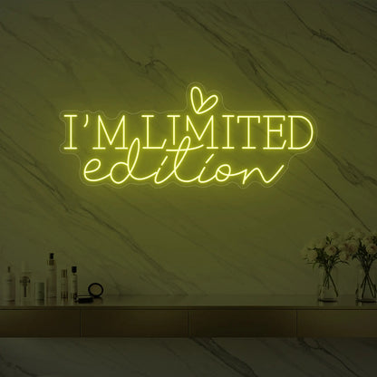 Photo of the 'I’M LIMITED edition' neon sign with a heart icon glowing in lemon yellow against a styled interior wall.
