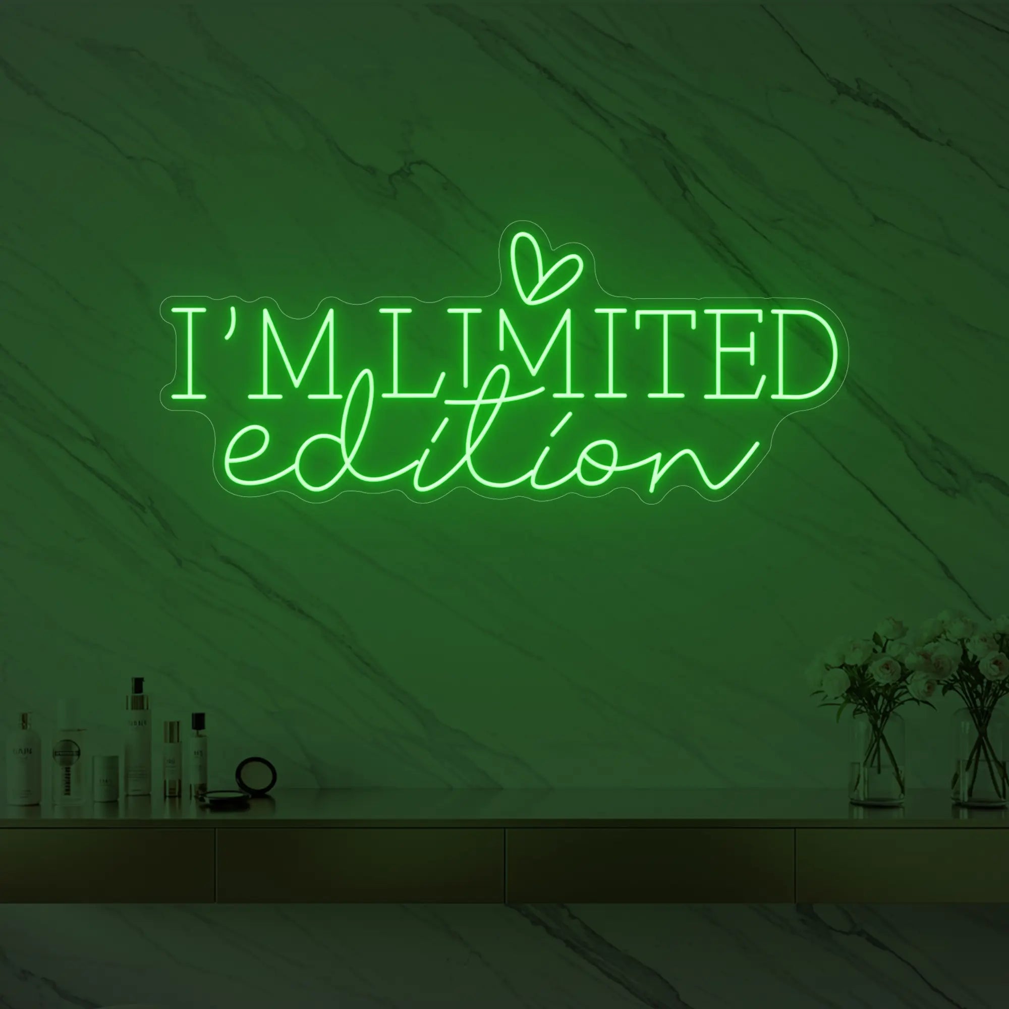Photo of the 'I’M LIMITED edition' neon sign with a heart icon glowing in green against a styled interior wall.