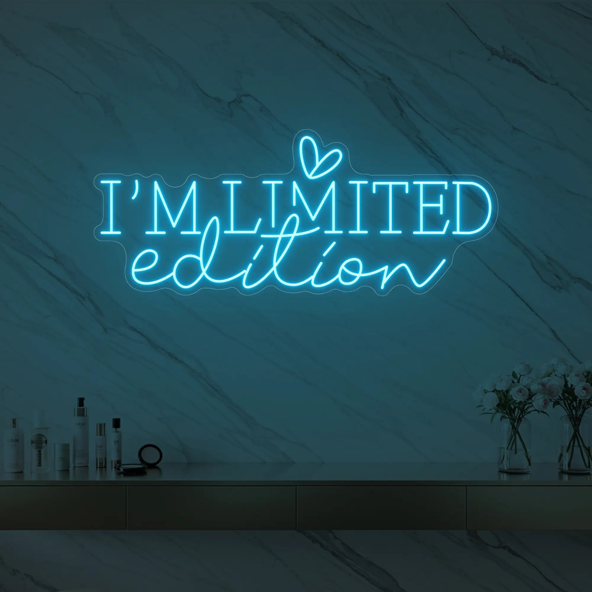 Photo of the 'I’M LIMITED edition' neon sign with a heart icon glowing in ice blue against a styled interior wall.