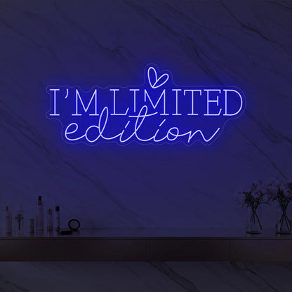 Photo of the 'I’M LIMITED edition' neon sign with a heart icon glowing in deep blue against a styled interior wall.