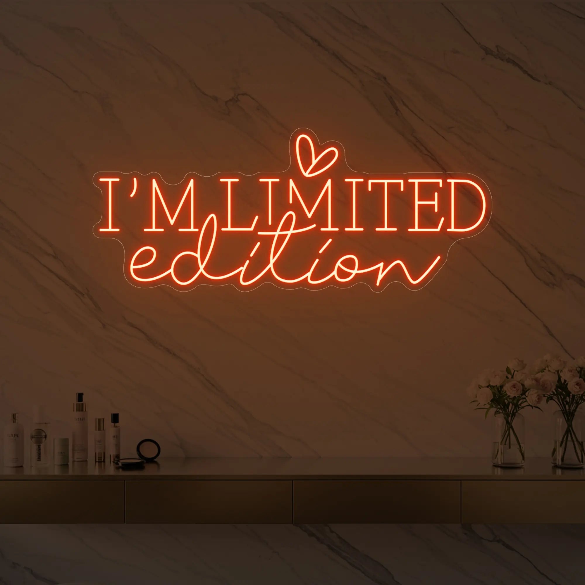 Photo of the 'I’M LIMITED edition' neon sign with a heart icon glowing in golden yellow against a styled interior wall.