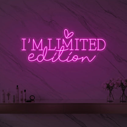 Photo of the 'I’M LIMITED edition' neon sign with a heart icon glowing in light pink against a styled interior wall.