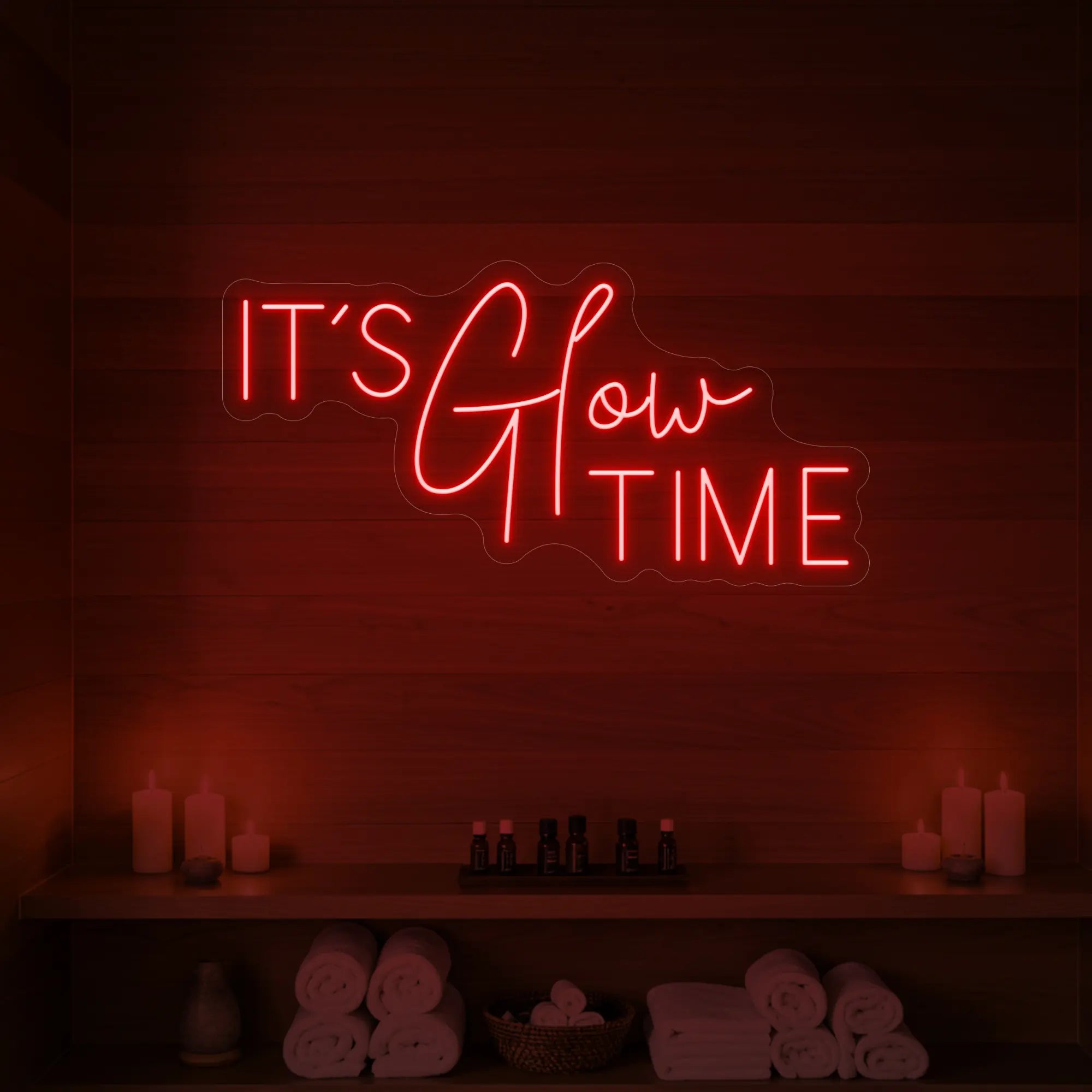 Photo of the 'IT’S Glow TIME' neon sign glowing in red against a styled interior wall.