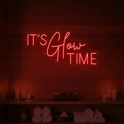 Photo of the 'IT’S Glow TIME' neon sign glowing in red against a styled interior wall.