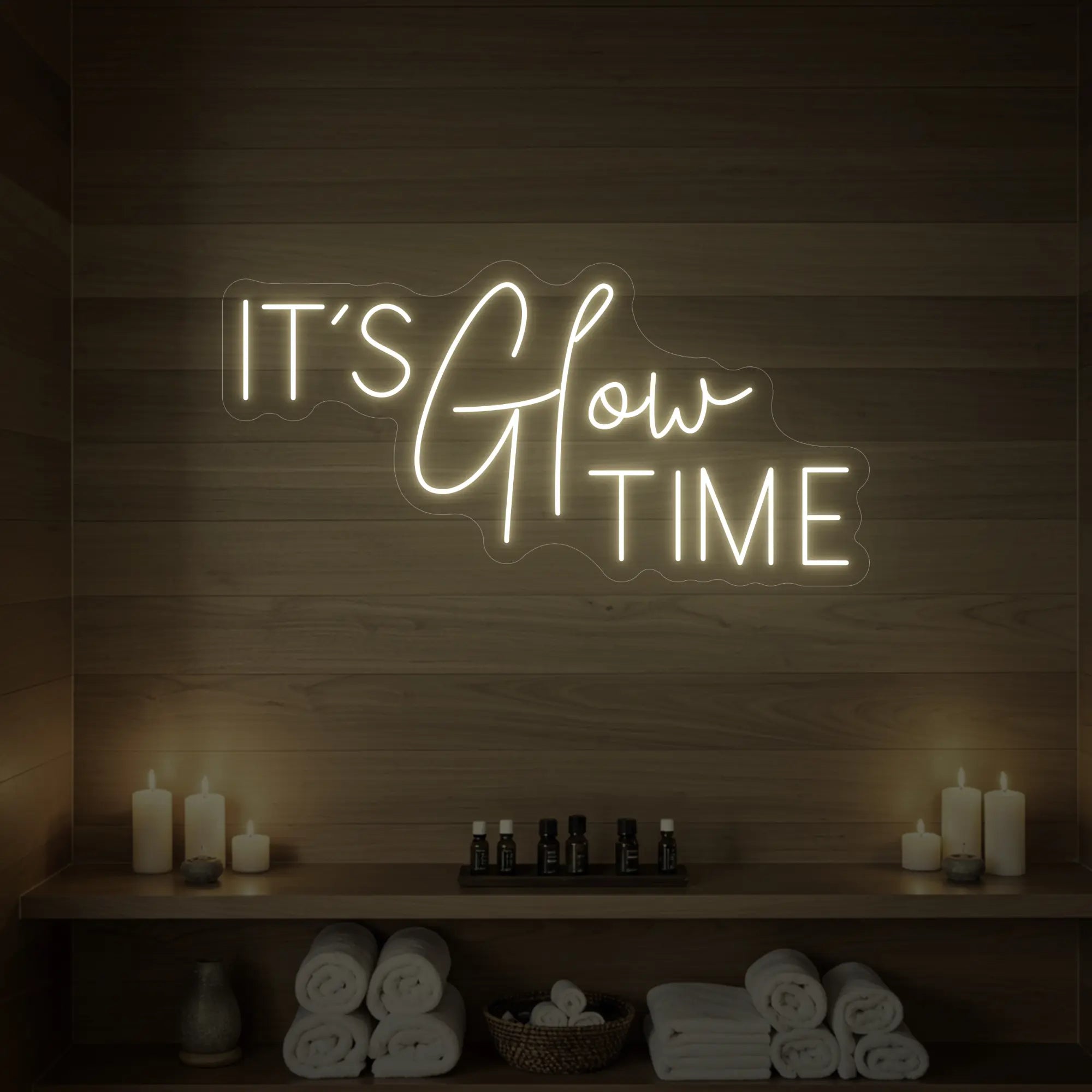 Photo of the 'IT’S Glow TIME' neon sign glowing in warm white against a styled interior wall.