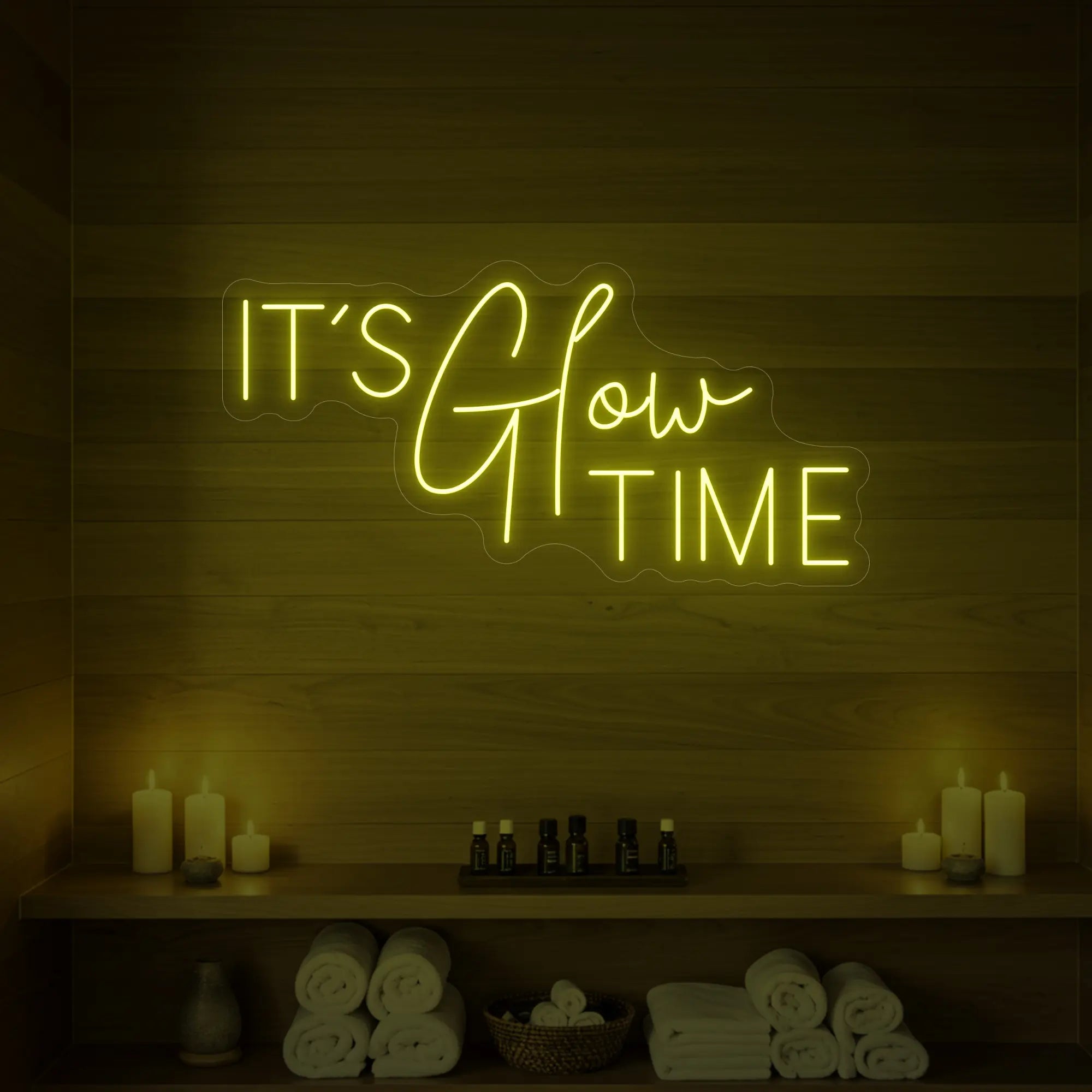 Photo of the 'IT’S Glow TIME' neon sign glowing in lemon yellow against a styled interior wall.
