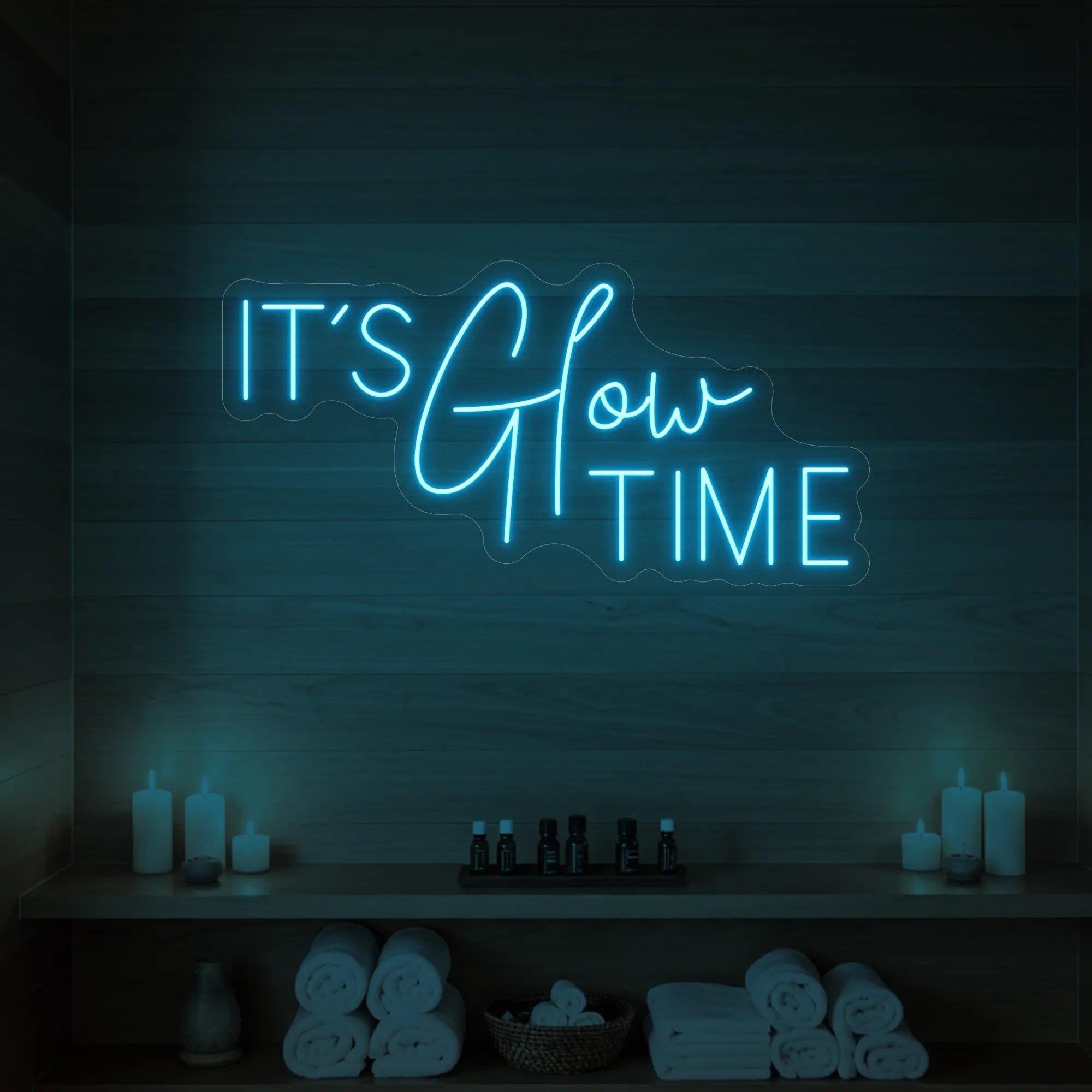 Photo of the 'IT’S Glow TIME' neon sign glowing in ice blue against a styled interior wall.