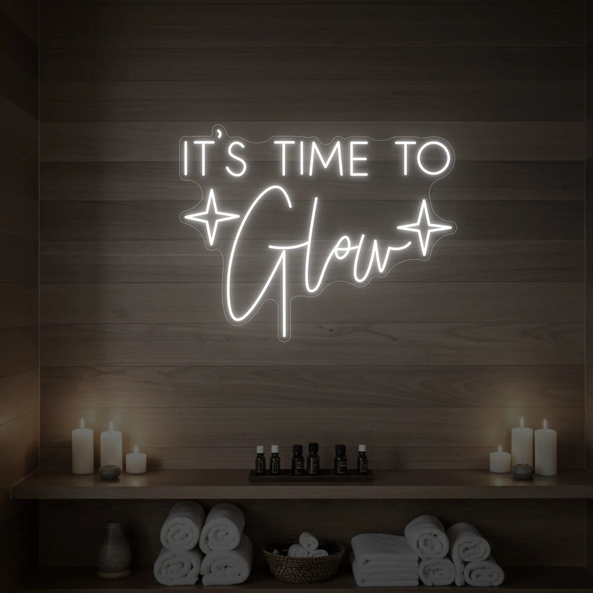 Photo of the 'IT’S TIME TO Glow' neon sign with sparkle icons glowing in cool white against a styled interior wall.