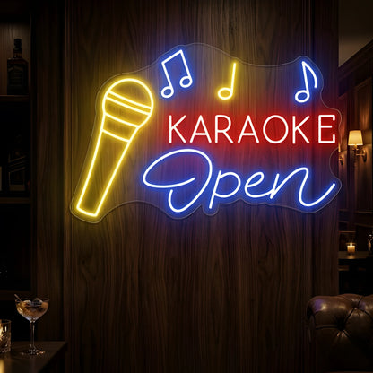Photo of the 'Karaoke Open' neon sign glowing in multi-color against a styled interior wall.