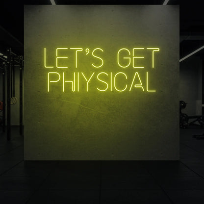  'LET'S GET PHYSICAL' neon sign glowing in lemon yellow against a styled interior wall.