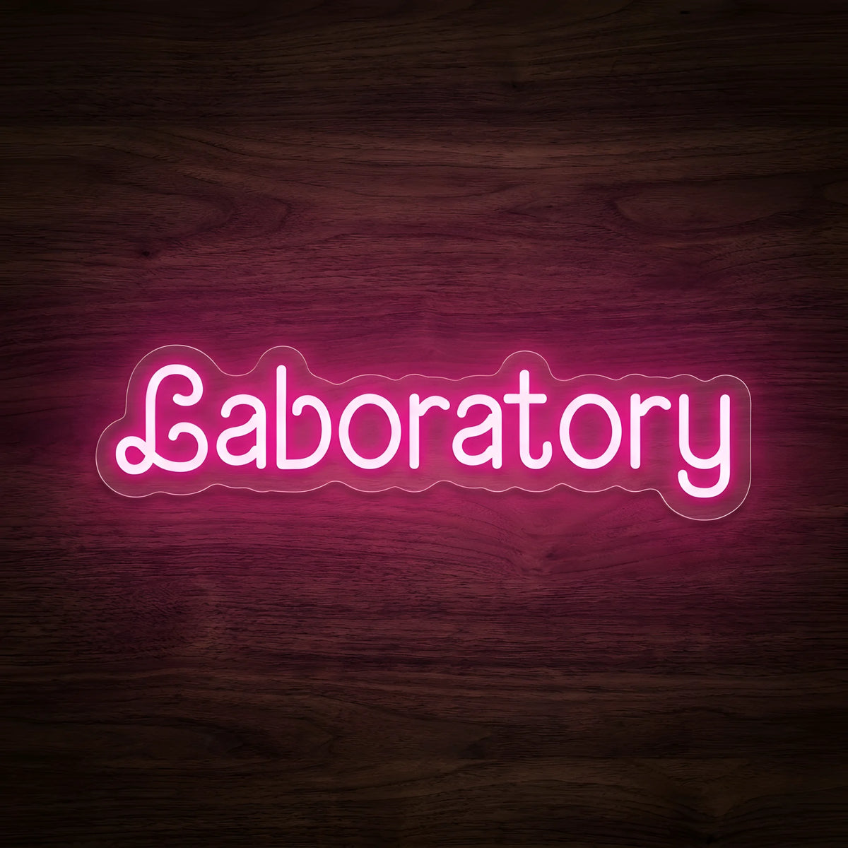 Pink Laboratory Script LED Neon Sign featuring rounded Laboratory lettering illuminated in vibrant pink on clear cut-to-shape acrylic backing against a dark wooden wall.
