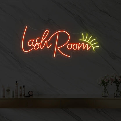 Photo of the 'Lash Room' neon sign with an eyelash icon glowing in golden yellow against a styled interior wall.