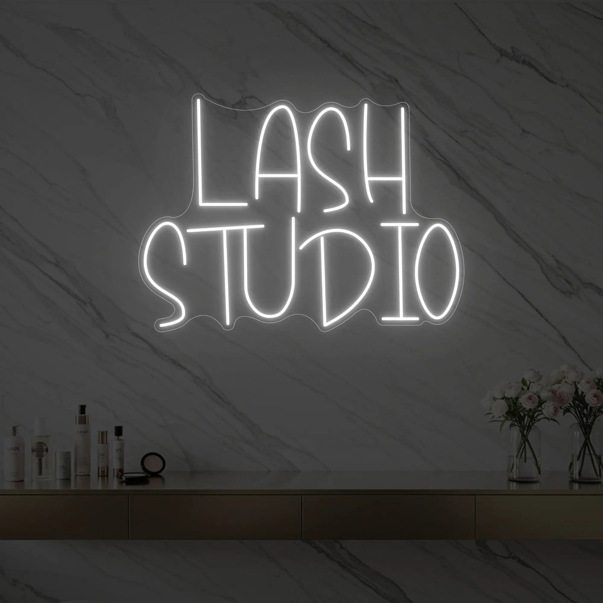 Photo of the 'LASH STUDIO' neon sign glowing in cool white against a styled interior wall.